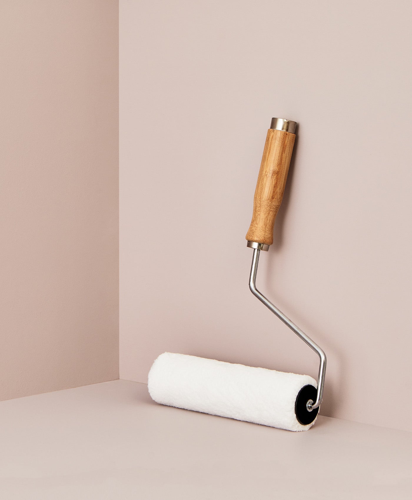 Mylands paint roller with wooden handle on a beige background