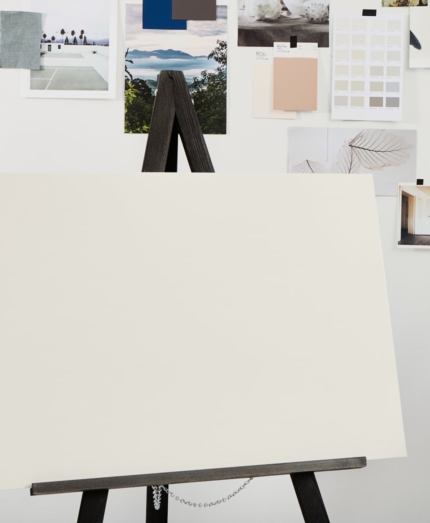 White canvas on a stand with color swatches and images in the background