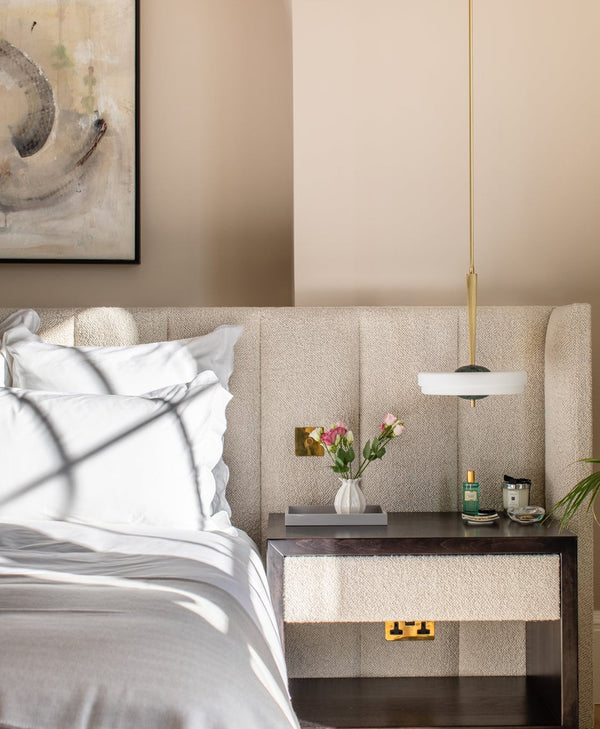Neutral modern bedroom with a bed, nightstand, and decorative elements.