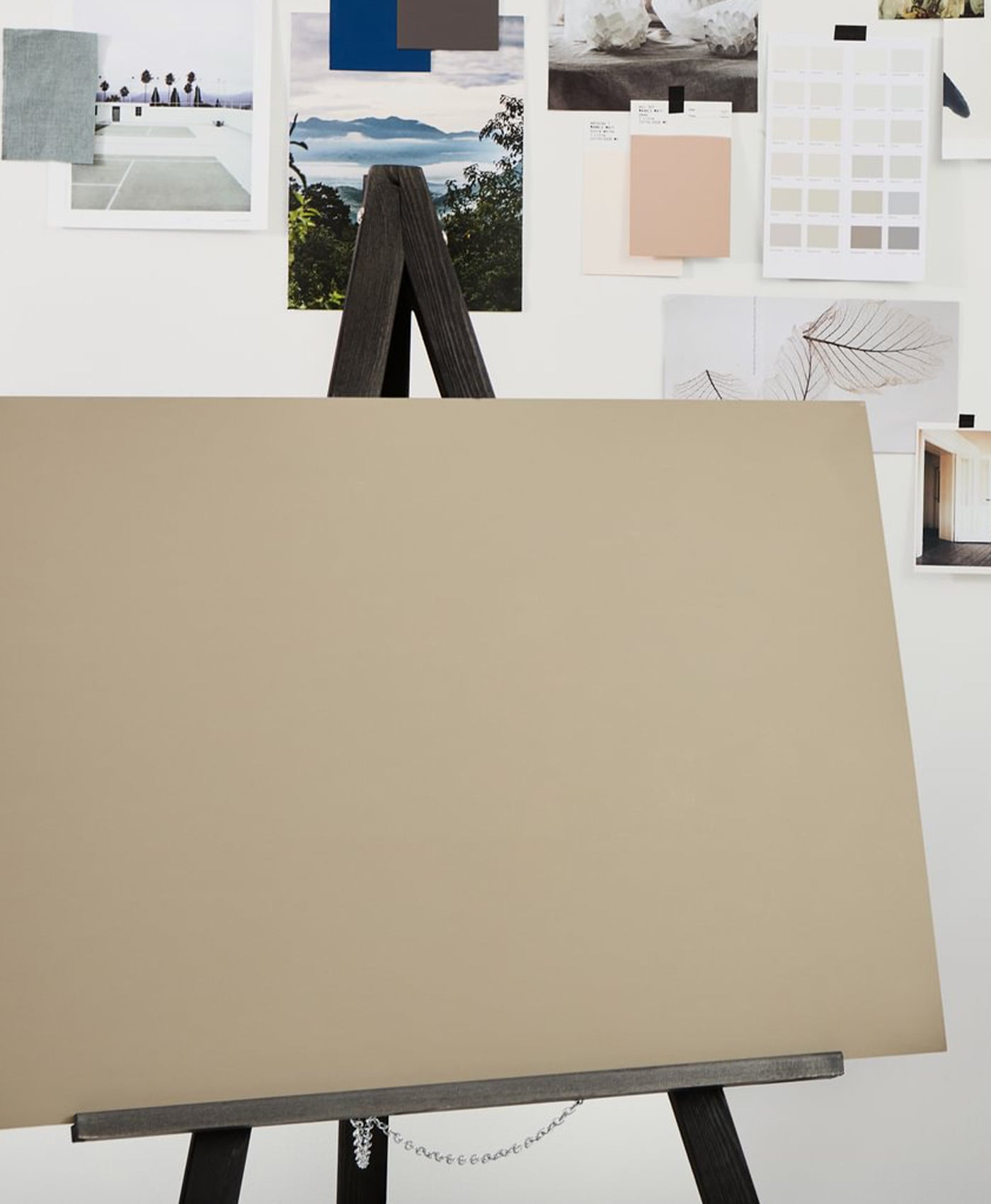 Beige canvas on an easel with color swatches and images in the background