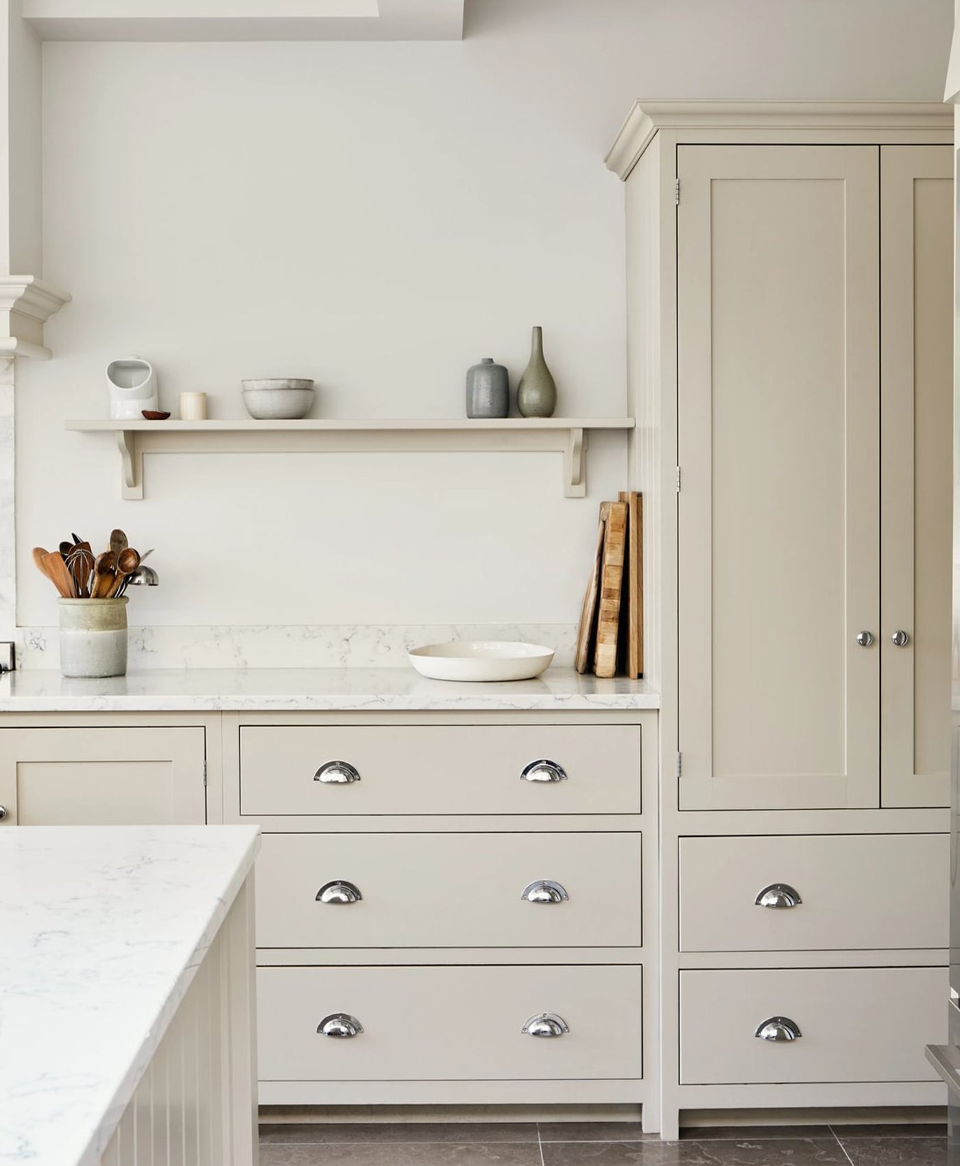 Kitchen with light grey cabinets, white walls and marble countertops