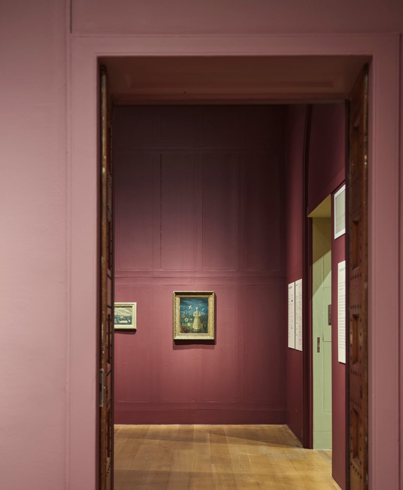 Art gallery with paintings on a deep red wall