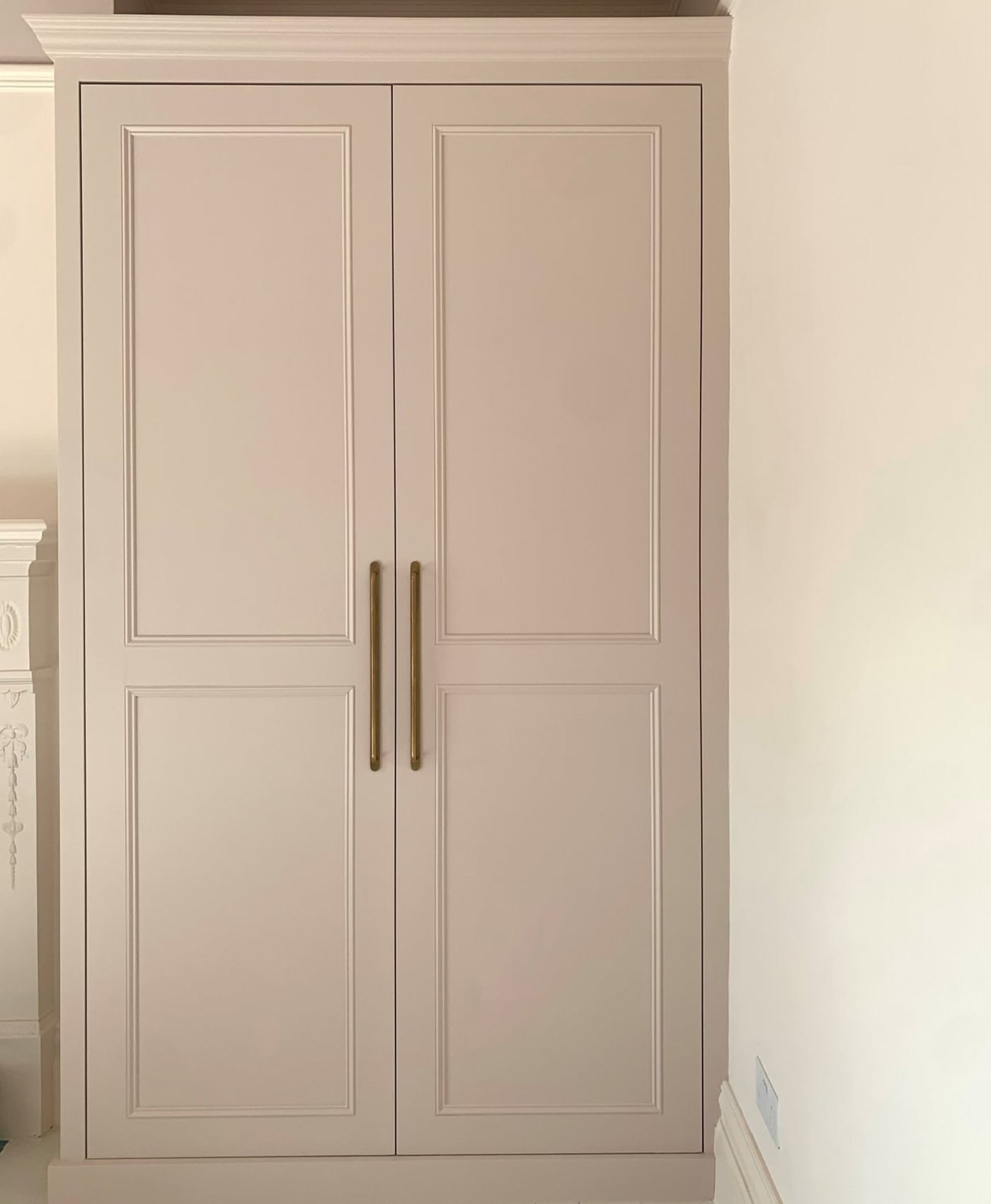 Beige wardrobe with gold handles in a neutral setting