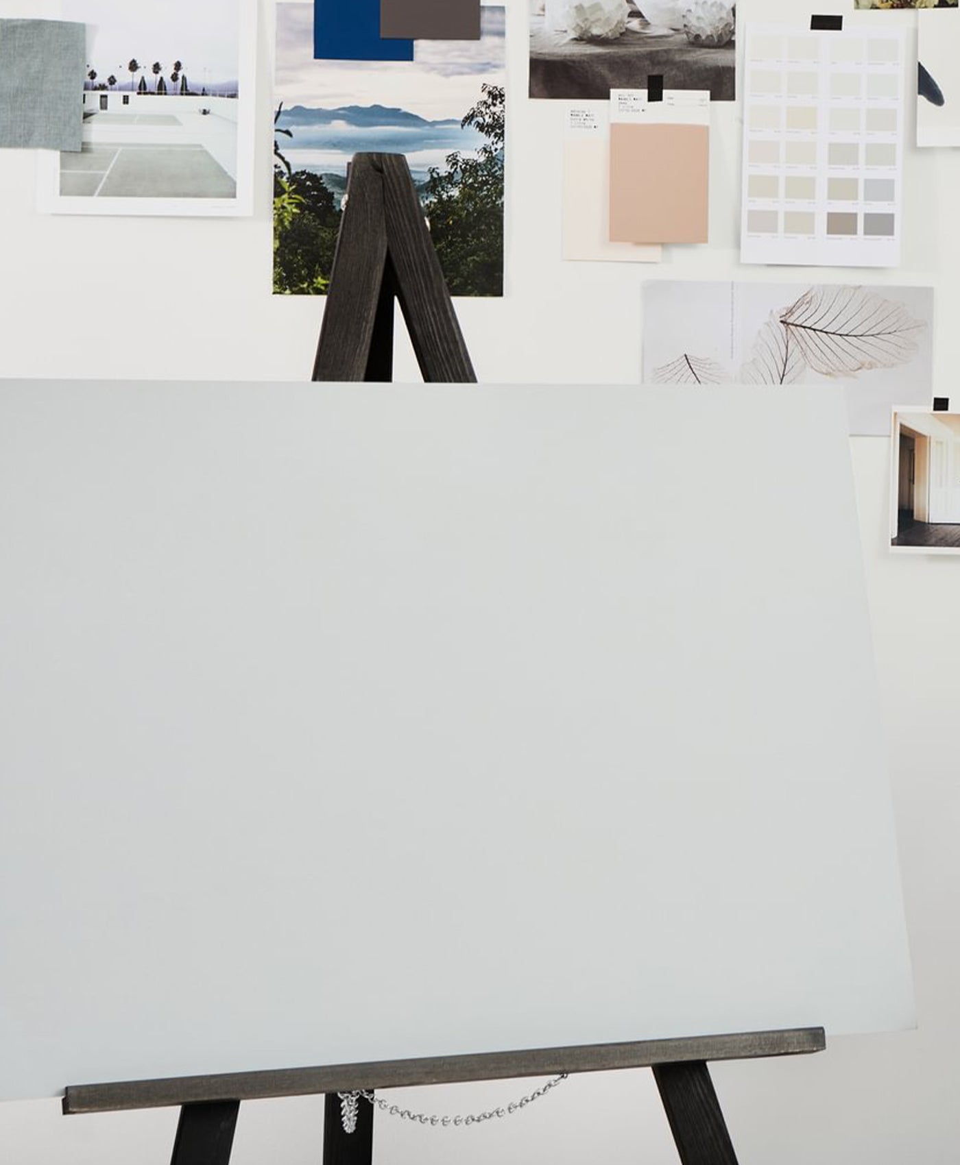 White canvas on a stand with various color swatches and images displayed above it.