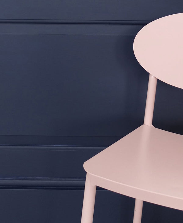 pale pink chair against a dark blue wall