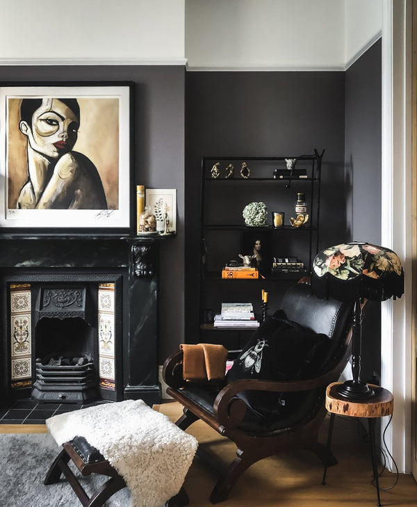 Living room with dark grey brown walls, a fireplace, and decorative items.