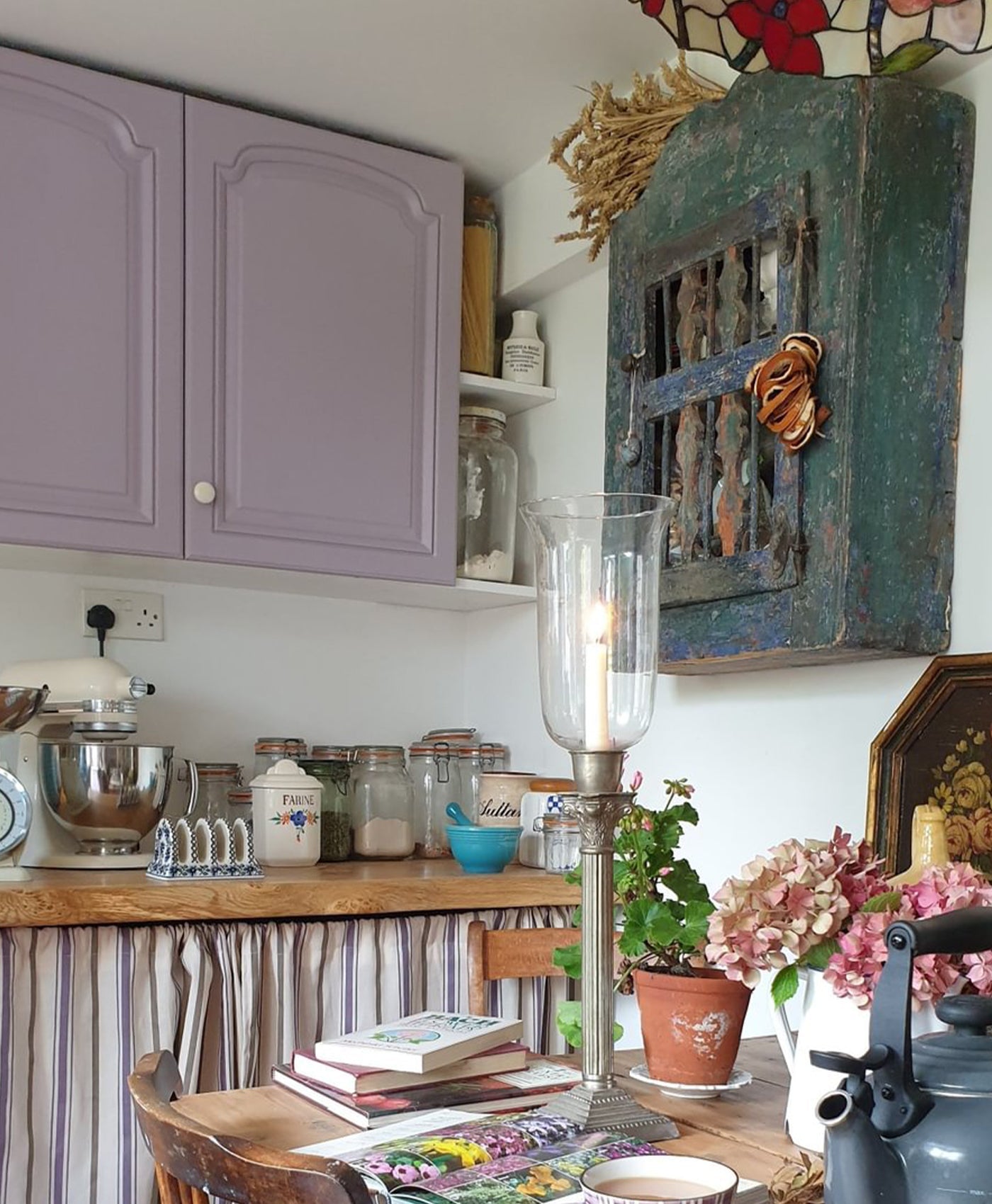 Kitchen with purple cabinets, wooden counter, and decorative items.