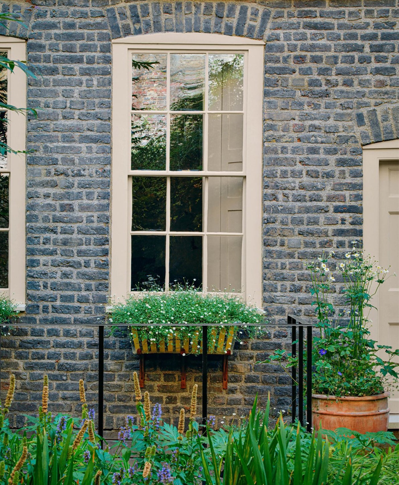 Grey brick wall with a window painted in earthy neutral paint
