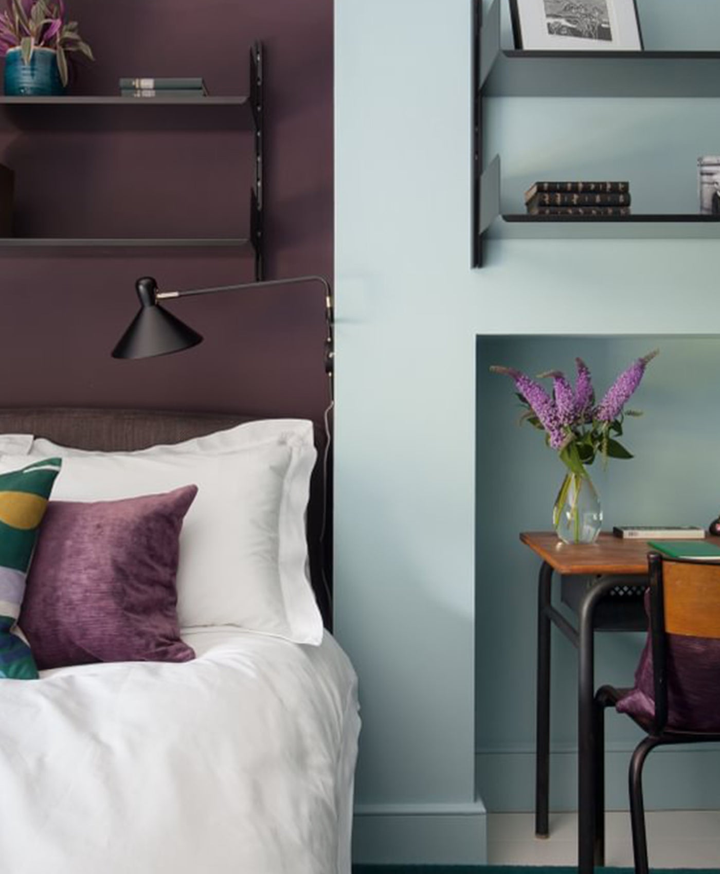 Bedroom with purple accents and aqua blue contrasts, white bedding, and a desk with a vase of flowers.