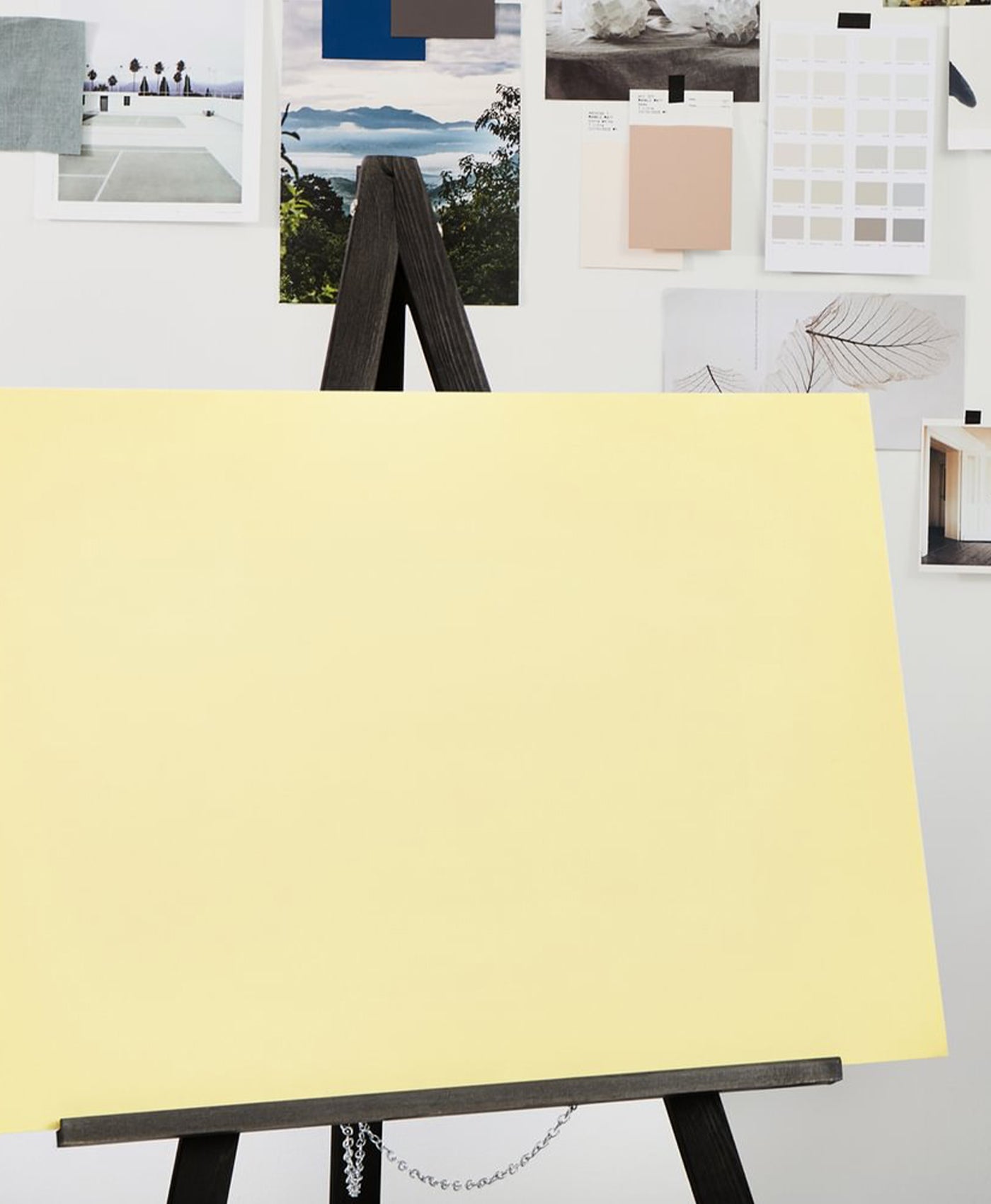 Yellow board on an easel with color swatches and images in the background