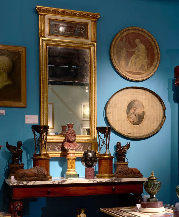 Vintage mirror and decorative items against a blue wall