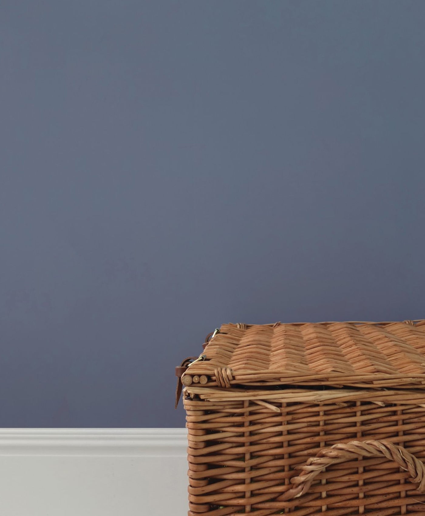 Wicker basket against a dark blue wall