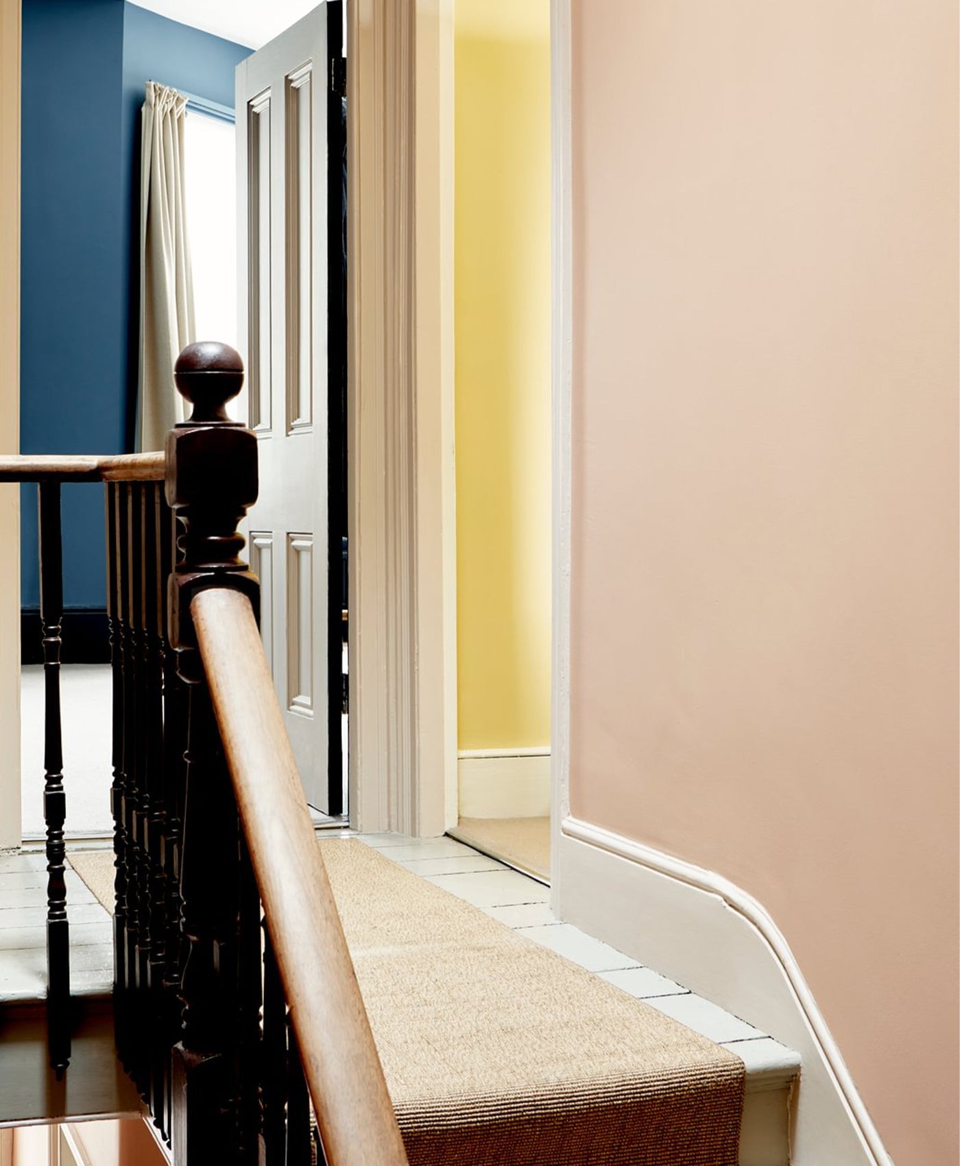 Staircase with wooden railing and carpeted steps in a home interior.
