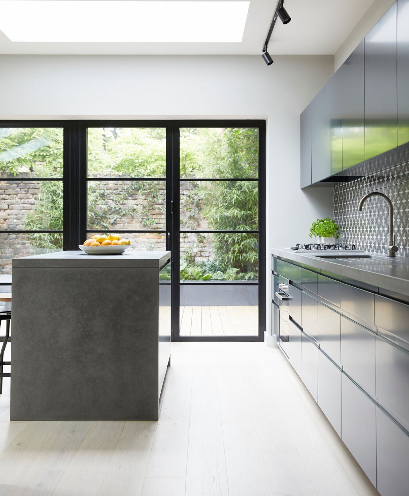 Modern cool grey kitchen with grey island and stainless steel cabinets.