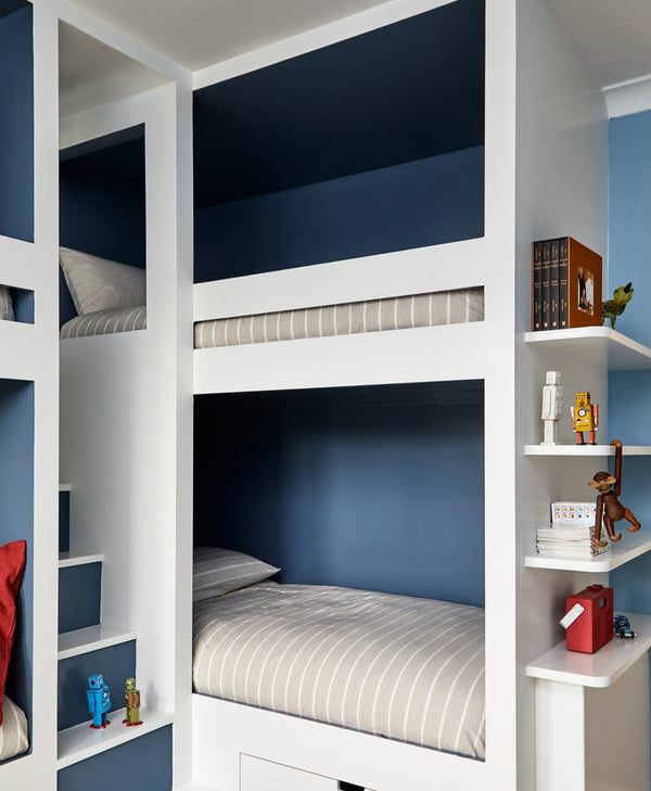 blue Bunk beds with shelves and bedding in a compact room