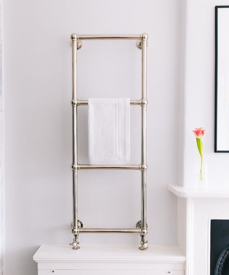 Towel rack with a white towel on a white wall