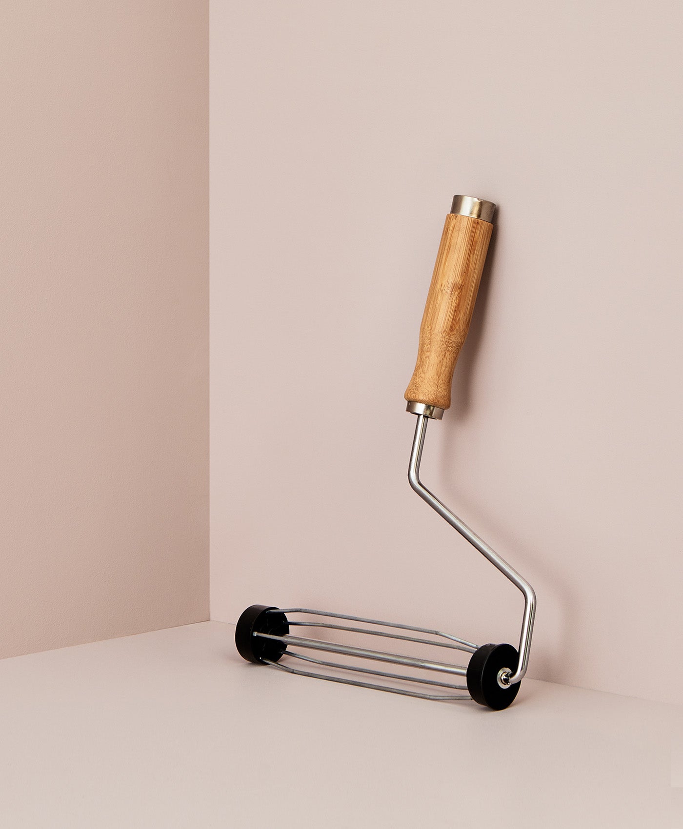 Mylands metal roller with wooden handle on a beige background