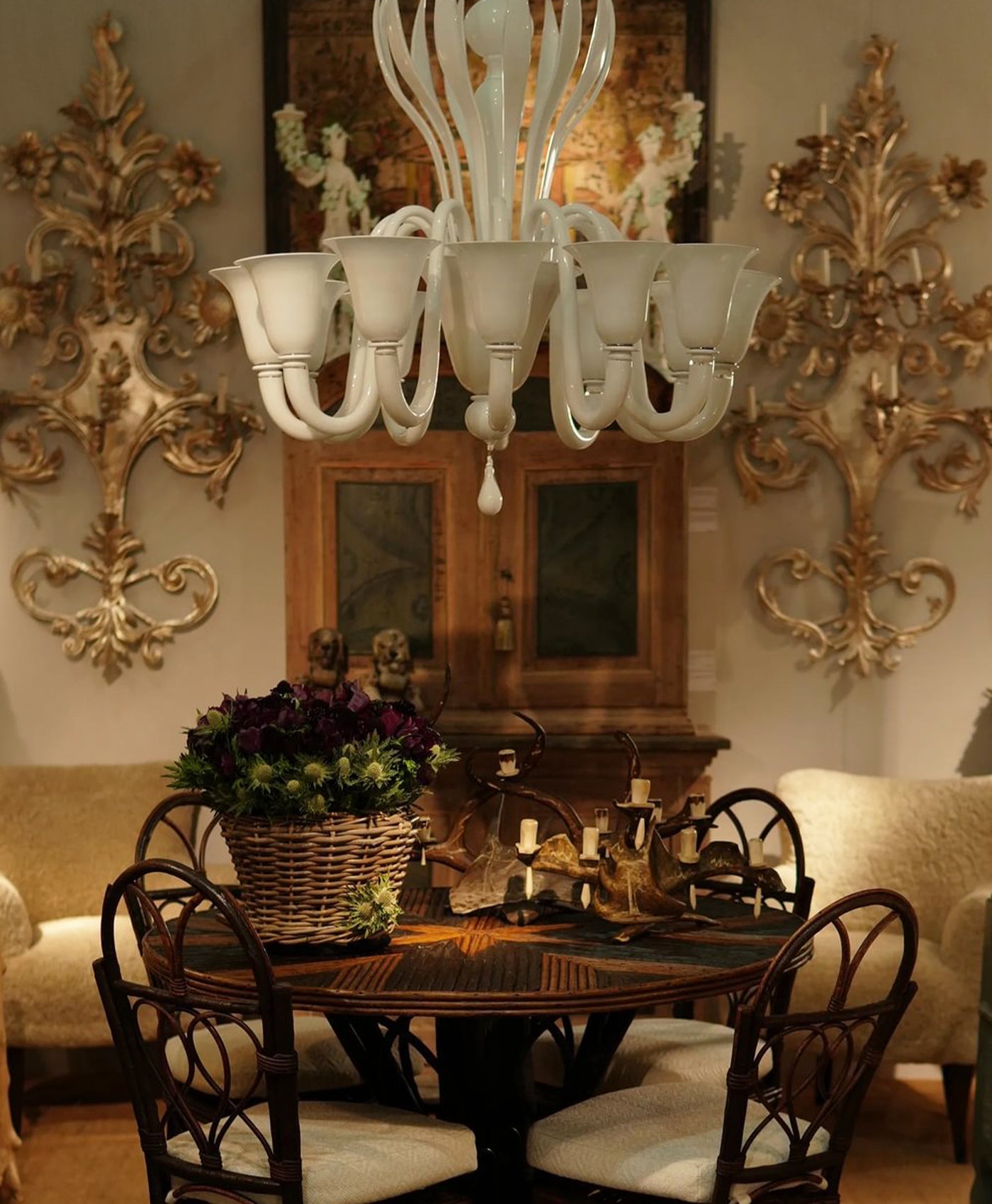Dining room with a chandelier, table, and chairs in a cool neutral decorated room.