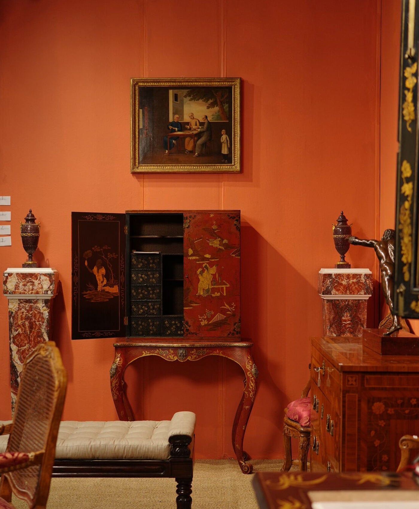 Vintage interior with ornate furniture and a painting on an orange wall