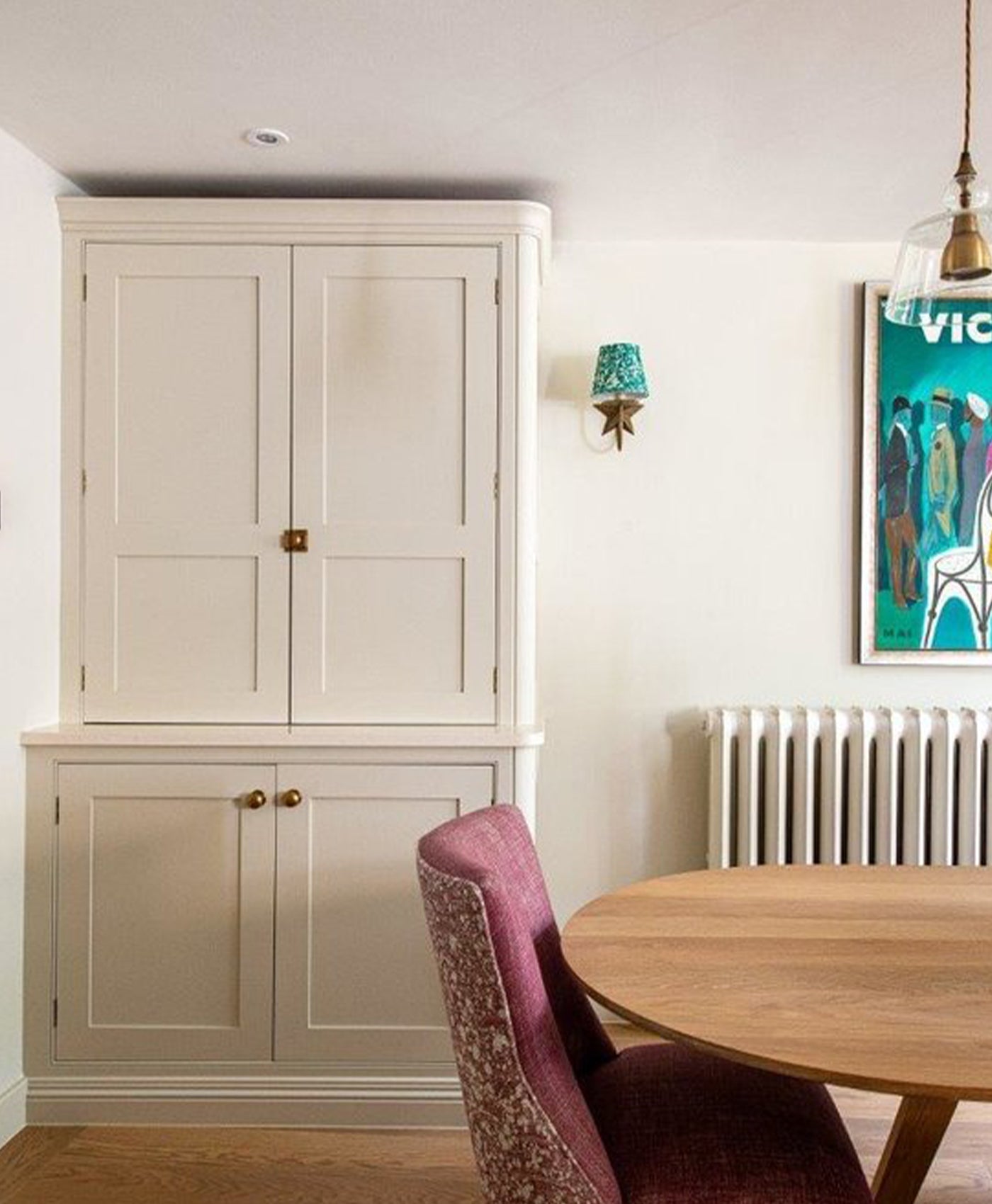 Dining room with beige cabinet, wooden table, and purple chair.