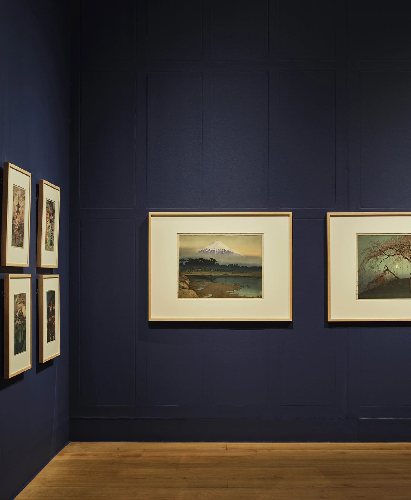 Art gallery with framed paintings on a dark blue wall