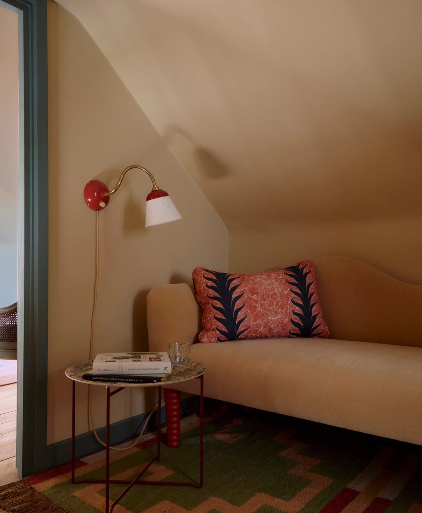 Cosy warm neutral living room with beige sofa, decorative pillow, and wall lamp.