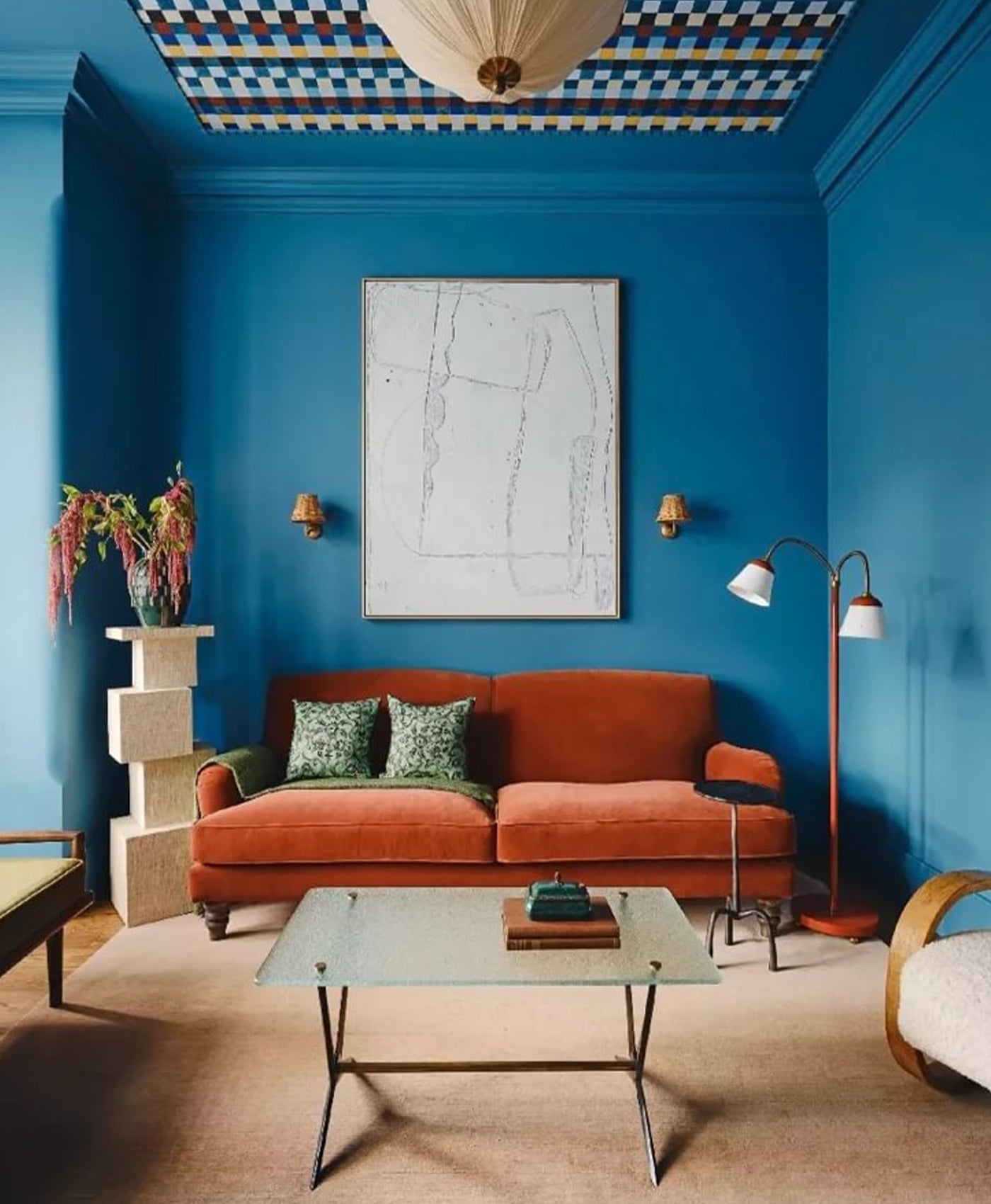 Vivid blue living room with orange sofa, and decorative elements.