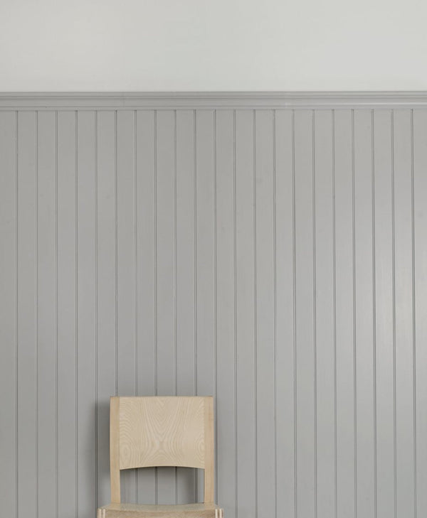 wooden chair against a silver grey panelled wall