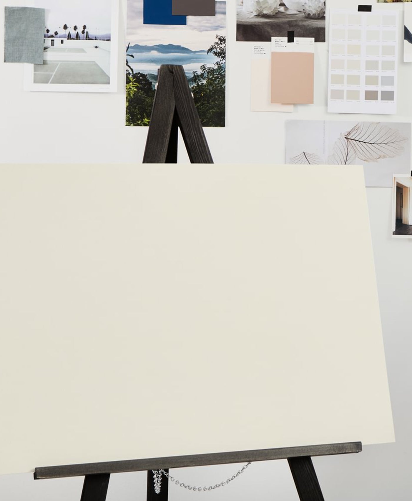 Blank canvas on an easel with color swatches and images in the background
