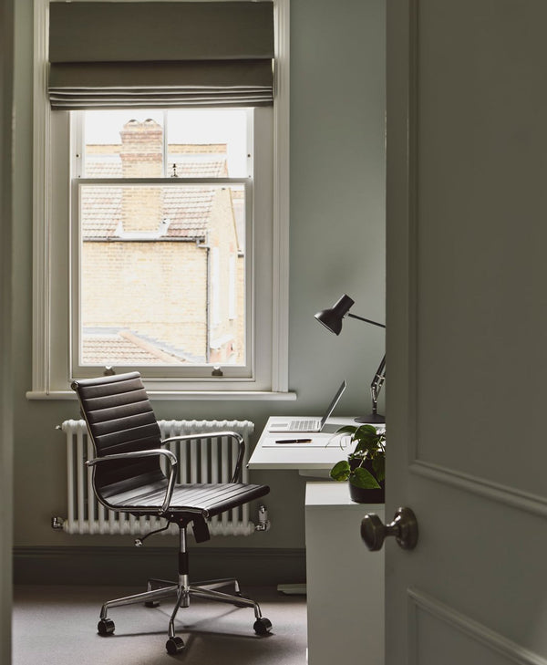 Home office with a desk, chair, and window, painted in blue green grey paint.