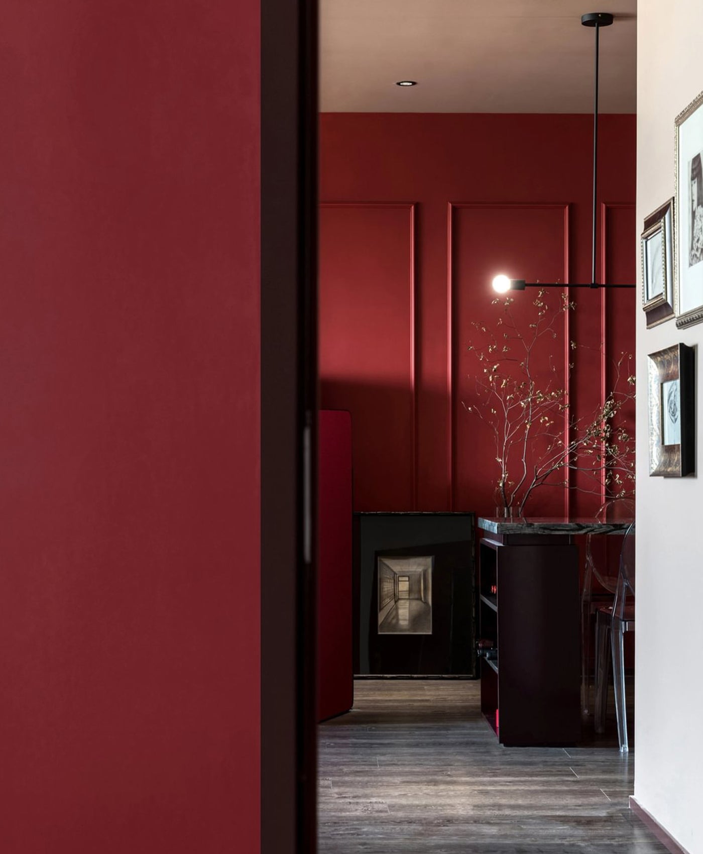 Modern interior with deep red walls and a black fireplace.