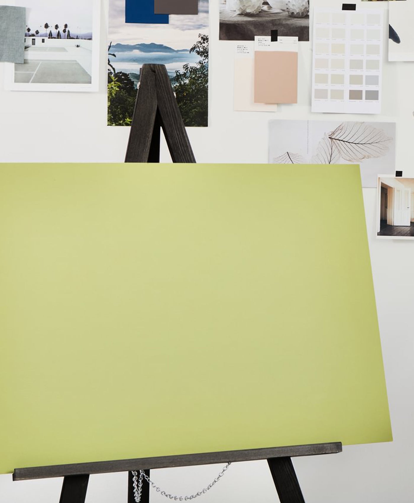 Green canvas on an easel with color swatches and images in the background