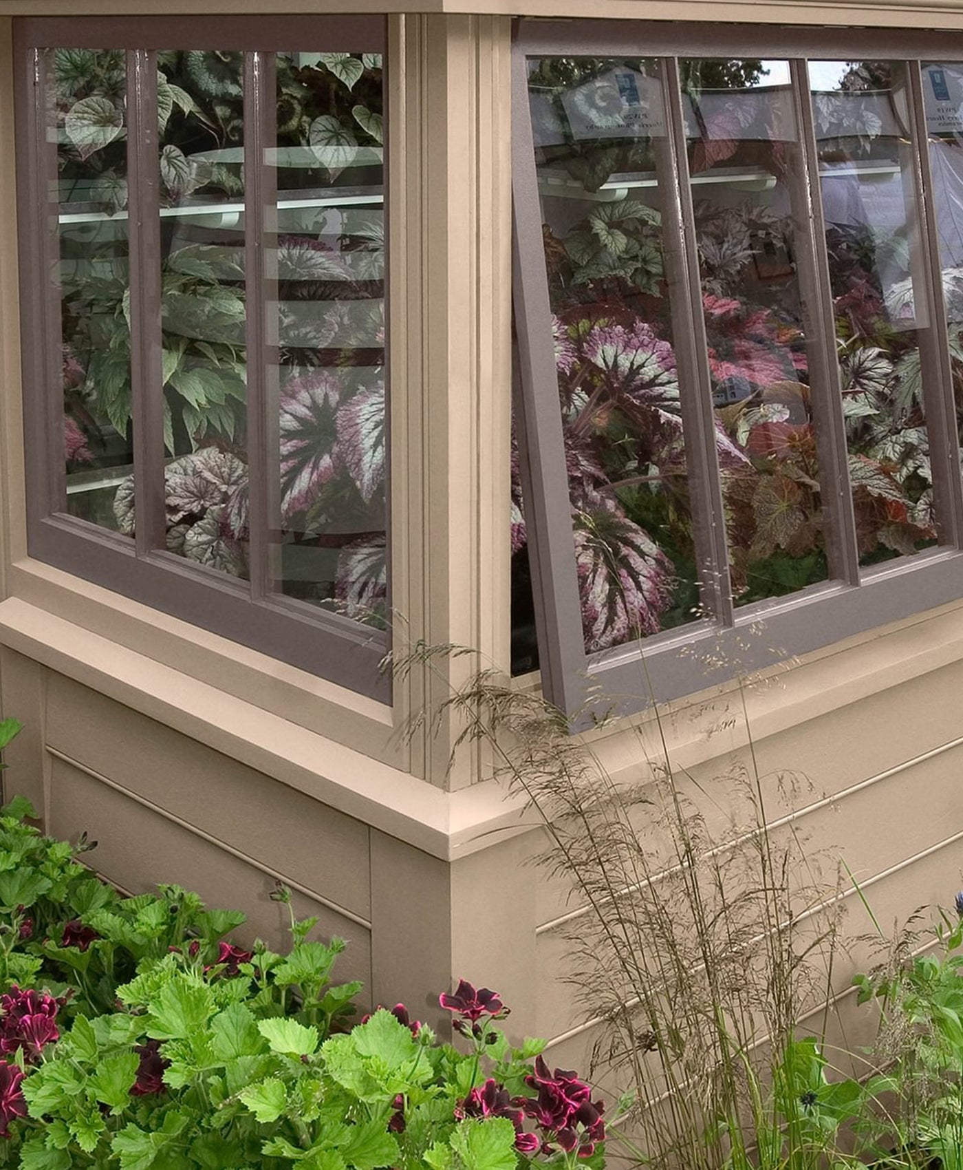 Garden shed painted in warm neutral paint with warm brown window frames