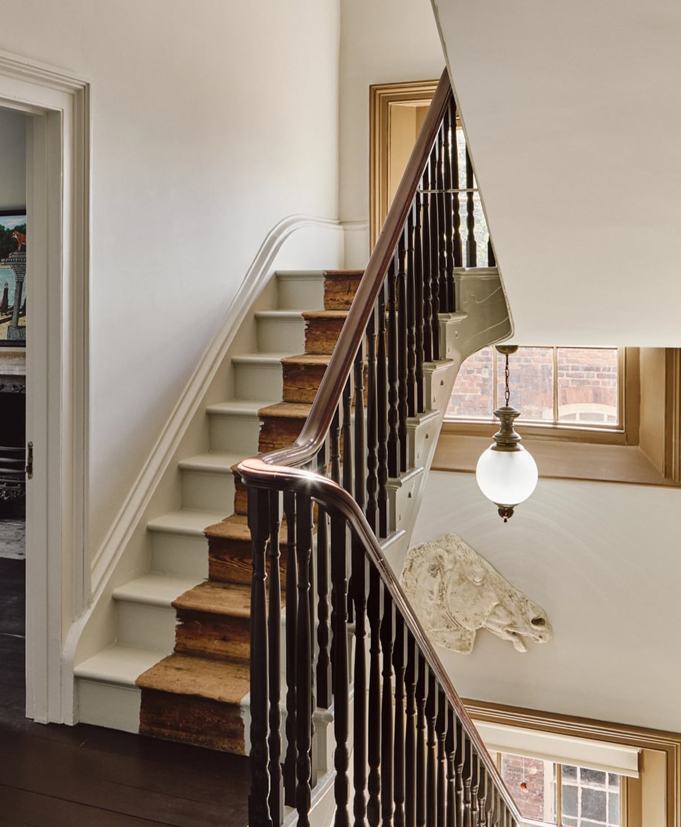 Staircase with wooden handrail and light green grey walls in a home interior.