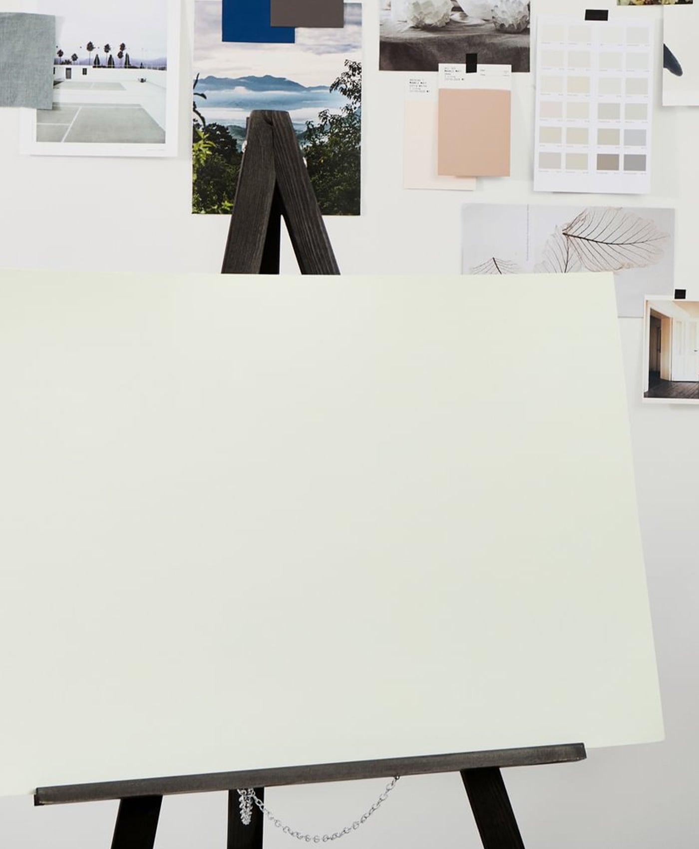 White canvas on a stand with color swatches and images in the background