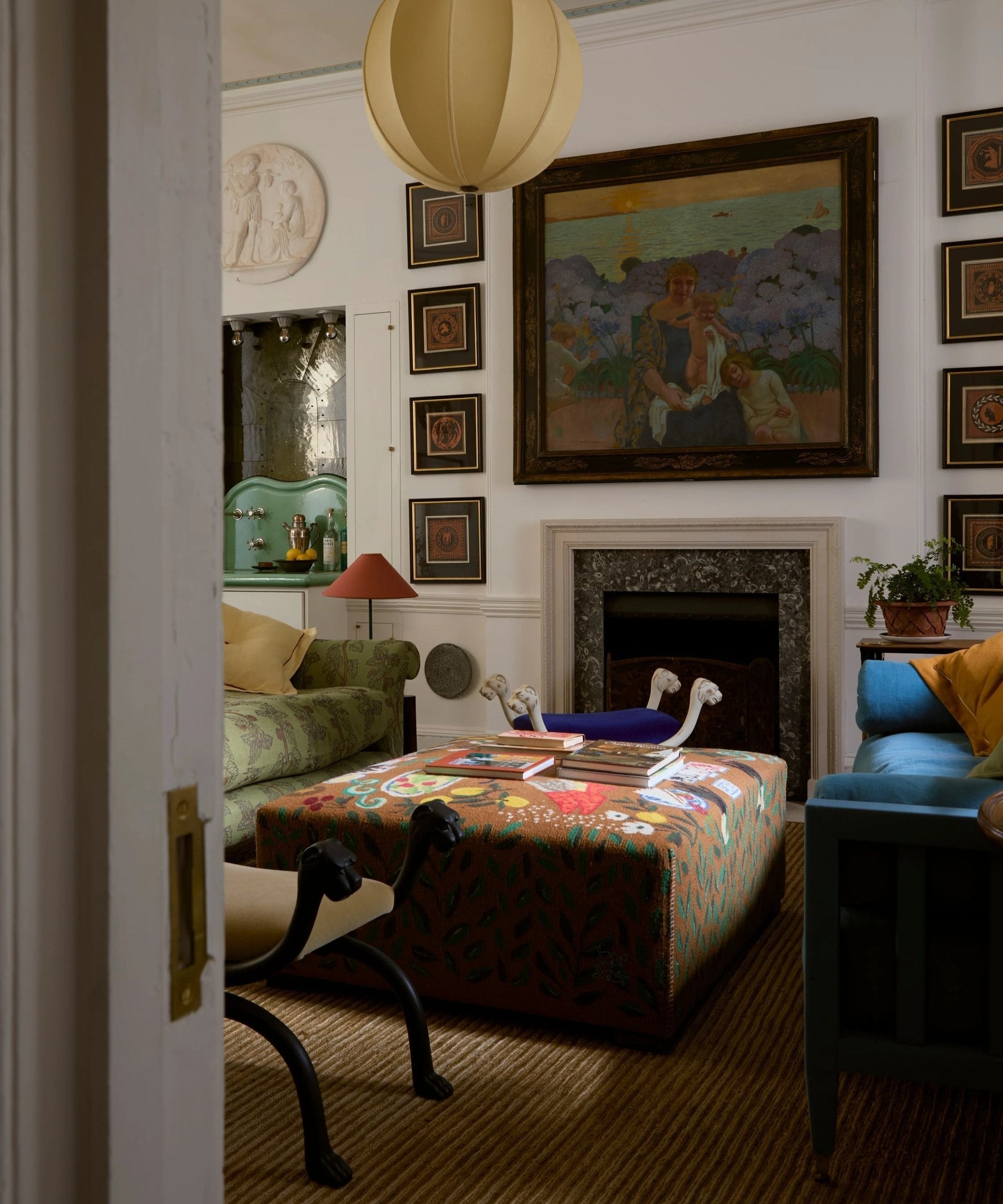 Living room in warm white with colourful furniture, artwork on the walls, and a fireplace.