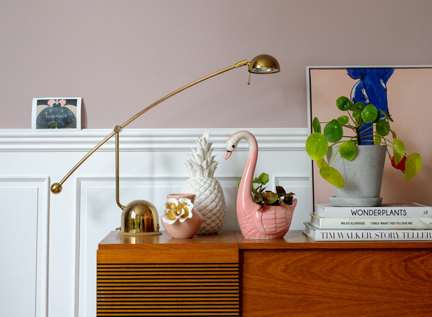 A lamp and desk in front of dusty deep magenta walls painted with Soho House No.266